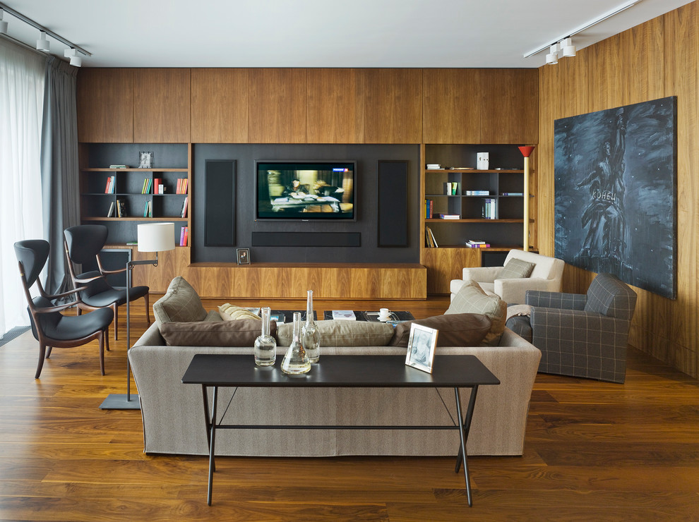 На фото: открытая гостиная комната в современном стиле с коричневыми стенами, паркетным полом среднего тона, мультимедийным центром и коричневым полом без камина с