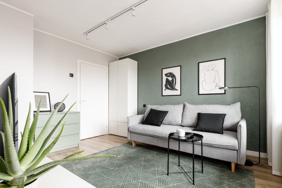 Inspiration for a small contemporary open plan living room in Saint Petersburg with green walls, laminate floors, a freestanding tv and brown floors.