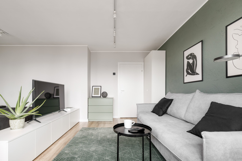 サンクトペテルブルクにある低価格の小さなコンテンポラリースタイルのおしゃれなLDK (緑の壁、ラミネートの床、据え置き型テレビ、茶色い床) の写真