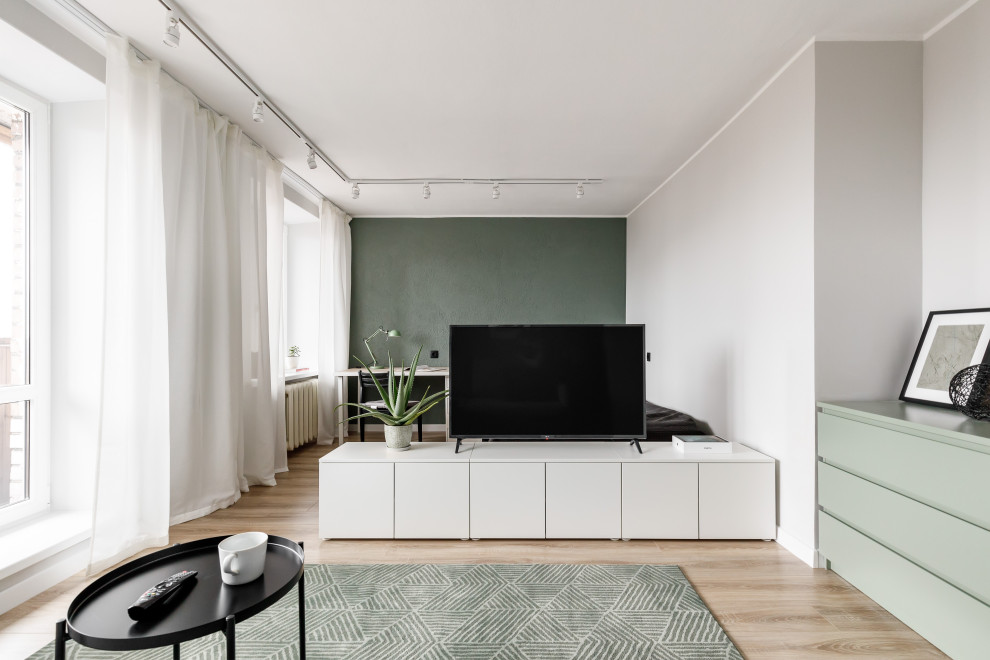 Kleines, Offenes Modernes Wohnzimmer mit grüner Wandfarbe, Laminat, freistehendem TV und braunem Boden in Sankt Petersburg