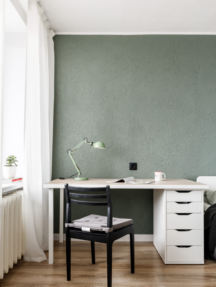Пример оригинального дизайна: маленькая открытая, объединенная гостиная комната в современном стиле с зелеными стенами, полом из ламината, отдельно стоящим телевизором и коричневым полом для на участке и в саду