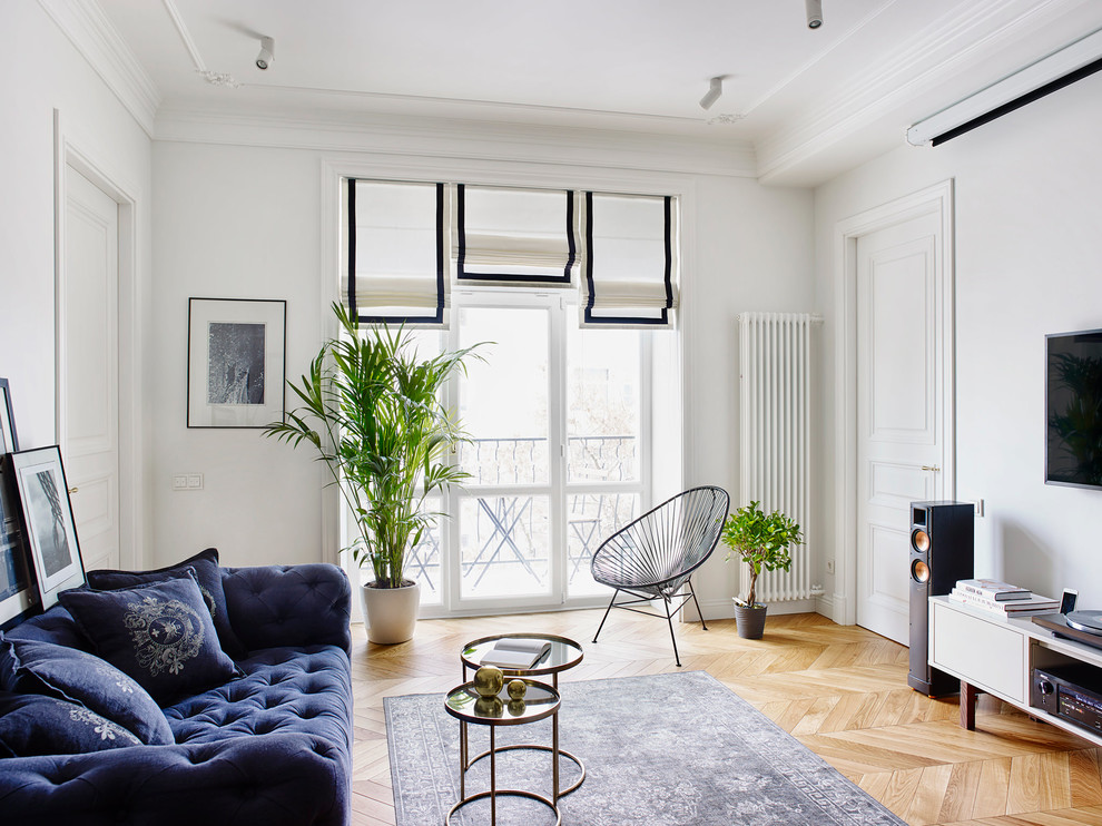 Immagine di un soggiorno boho chic con sala formale, pareti bianche, pavimento in legno massello medio e TV a parete