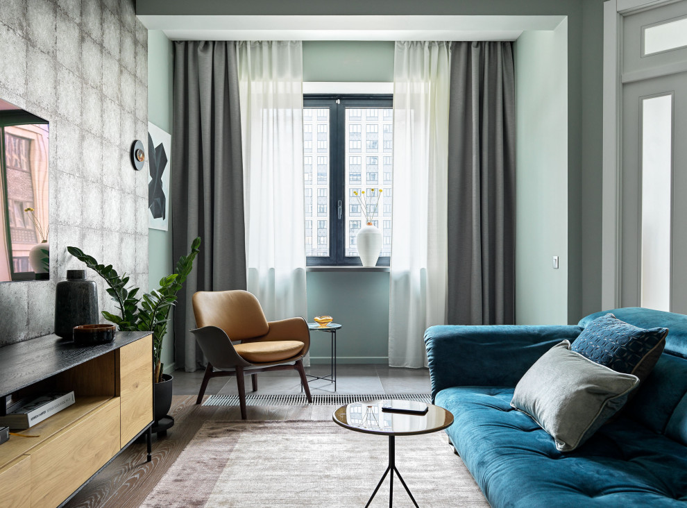 На фото: маленькая открытая гостиная комната в современном стиле с серыми стенами, паркетным полом среднего тона, телевизором на стене и коричневым полом без камина для на участке и в саду