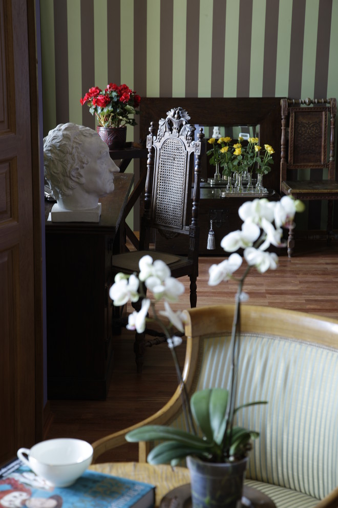 На фото: гостиная комната в стиле неоклассика (современная классика) с коричневым полом с