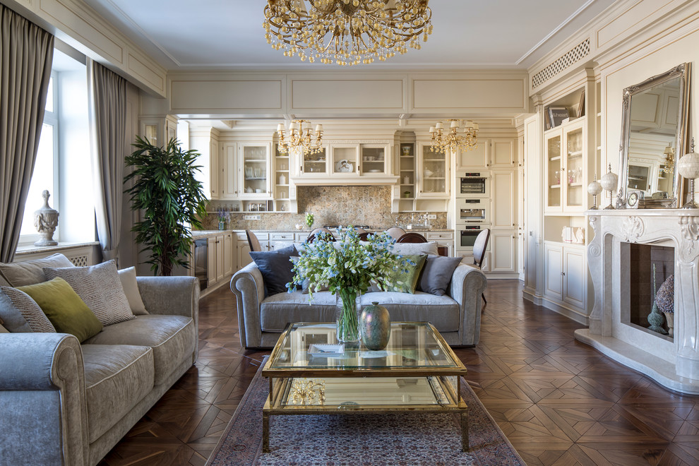 Réalisation d'un grand salon tradition ouvert avec un mur beige, un sol en bois brun, une cheminée standard, un manteau de cheminée en pierre et une salle de réception.