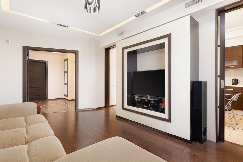 Imagen de salón cerrado actual de tamaño medio sin chimenea con paredes beige, suelo de madera oscura, televisor independiente y suelo marrón