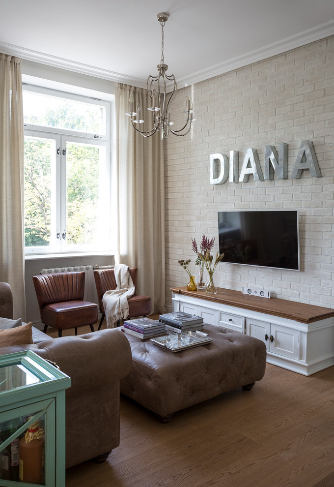 Esempio di un soggiorno design con pareti beige, pavimento in legno massello medio e TV a parete