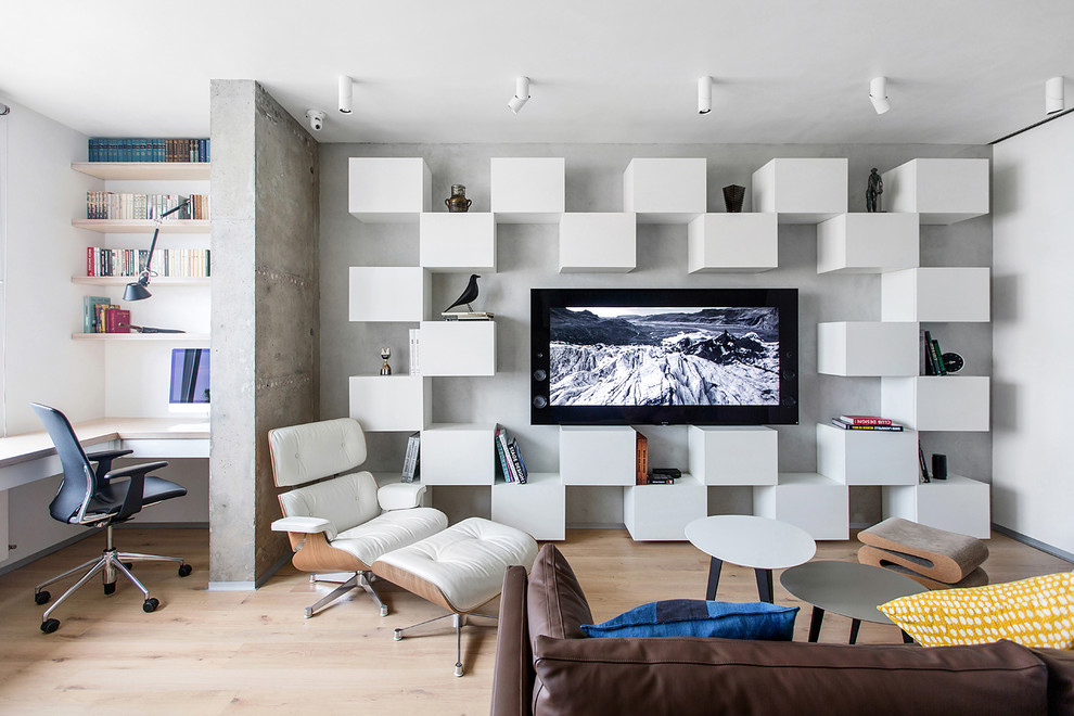 Diseño de salón para visitas abierto actual con paredes grises, suelo de madera clara y televisor colgado en la pared