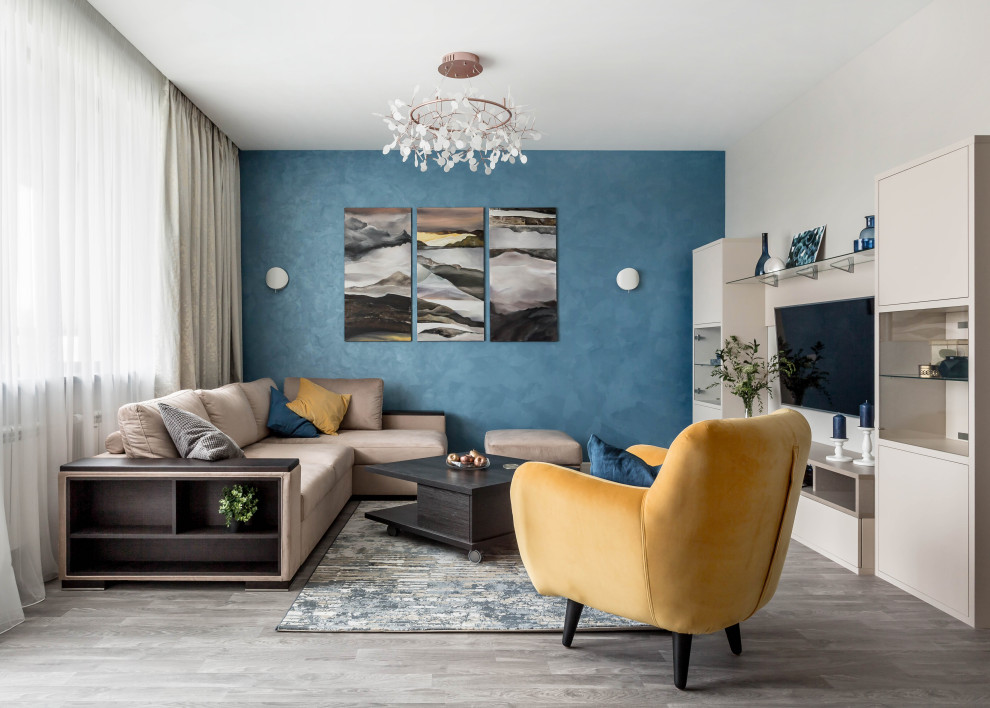 Идея дизайна: гостиная комната в современном стиле с синими стенами, телевизором на стене, серым полом и тюлем на окнах