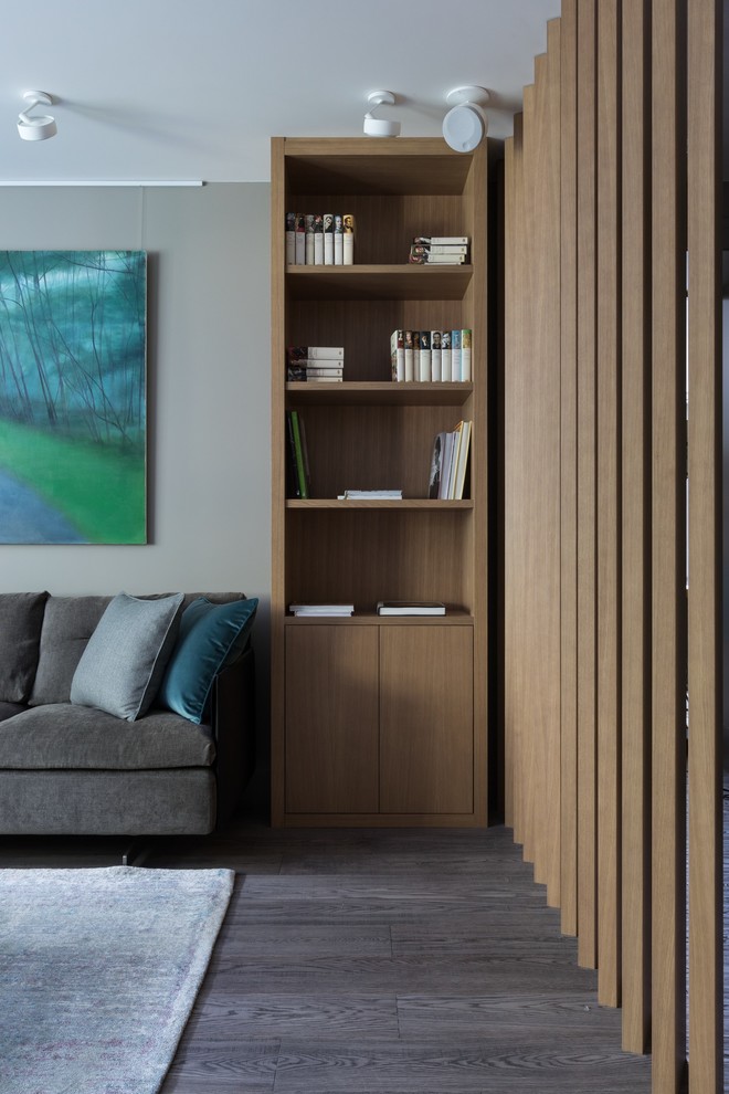 Foto på ett mellanstort funkis vardagsrum, med beige väggar, mellanmörkt trägolv och grått golv