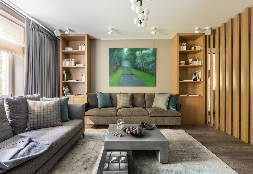 Cette image montre une grande salle de séjour design avec un mur beige, un sol en bois brun et un sol gris.