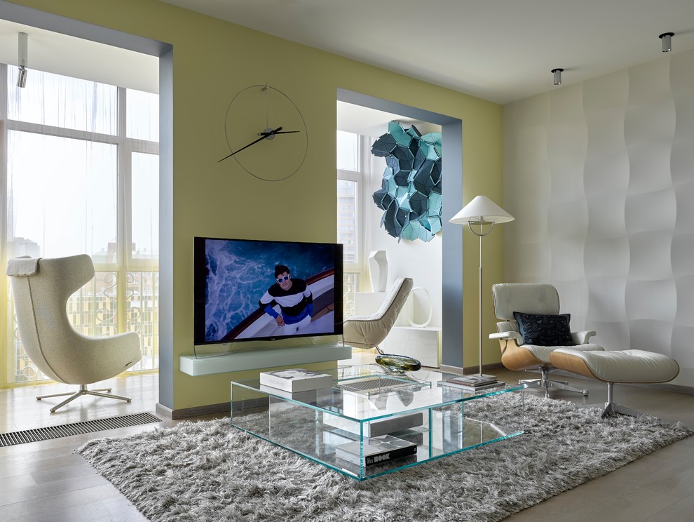Foto di un soggiorno design aperto con pareti gialle, parquet chiaro, TV autoportante e pavimento beige