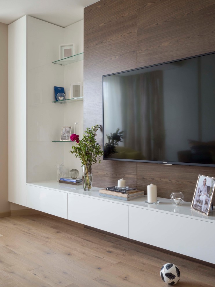На фото: изолированная гостиная комната среднего размера в современном стиле с бежевыми стенами, паркетным полом среднего тона, телевизором на стене и бежевым полом