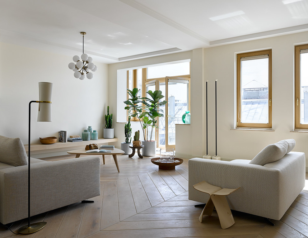 Immagine di un soggiorno nordico con pareti bianche, parquet chiaro e pavimento beige