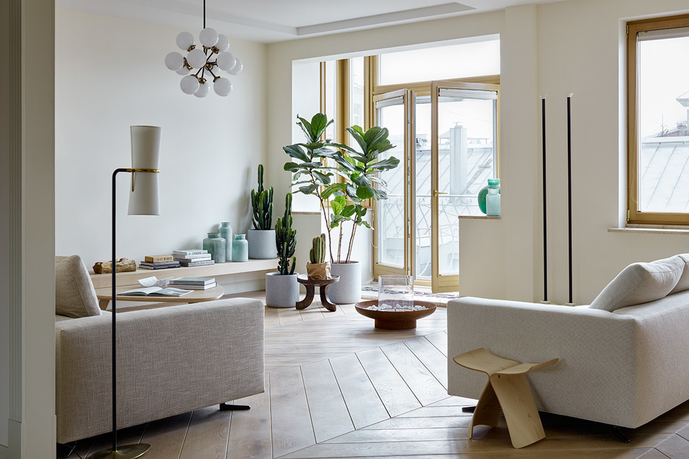 This is an example of a scandinavian living room in Moscow with white walls, light hardwood flooring and beige floors.