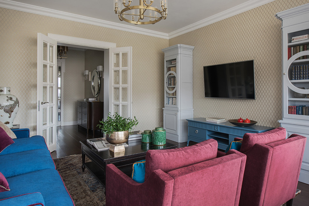 На фото: изолированная гостиная комната среднего размера в стиле неоклассика (современная классика) с бежевыми стенами, темным паркетным полом, телевизором на стене, коричневым полом и синим диваном