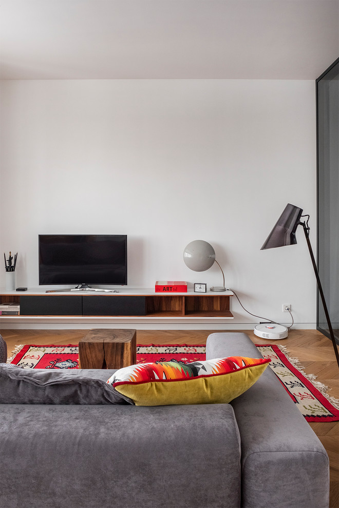 Kleines Modernes Wohnzimmer mit weißer Wandfarbe, braunem Holzboden, freistehendem TV und beigem Boden in Moskau