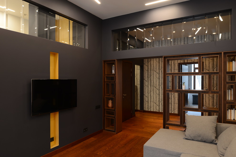 Свежая идея для дизайна: большая открытая, парадная гостиная комната в современном стиле с черными стенами, паркетным полом среднего тона и телевизором на стене - отличное фото интерьера