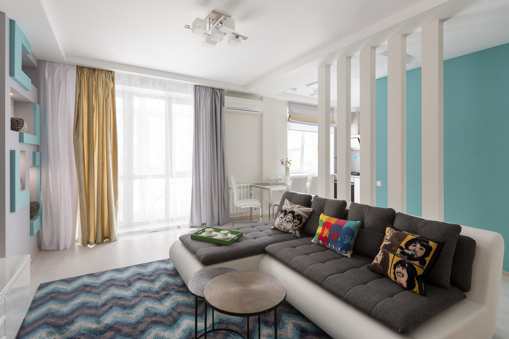 На фото: изолированная, объединенная гостиная комната среднего размера в современном стиле с серыми стенами, полом из ламината, телевизором на стене и белым полом с