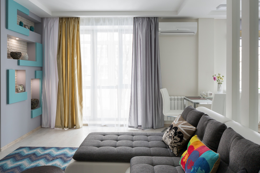 Пример оригинального дизайна: изолированная, объединенная гостиная комната среднего размера в современном стиле с серыми стенами, полом из ламината, телевизором на стене и белым полом