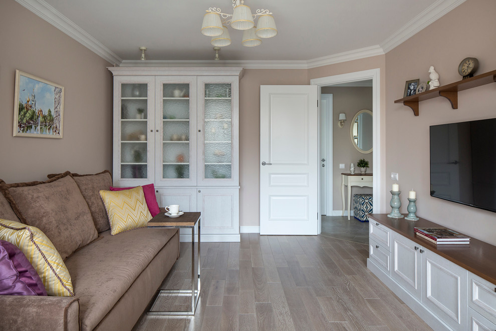Foto de salón cerrado tradicional de tamaño medio con paredes beige, televisor colgado en la pared y suelo de madera clara