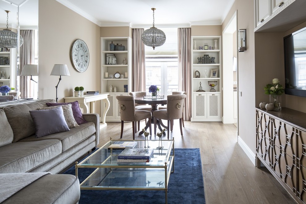 Foto di un soggiorno classico aperto con sala formale, pareti beige, parquet chiaro e TV a parete