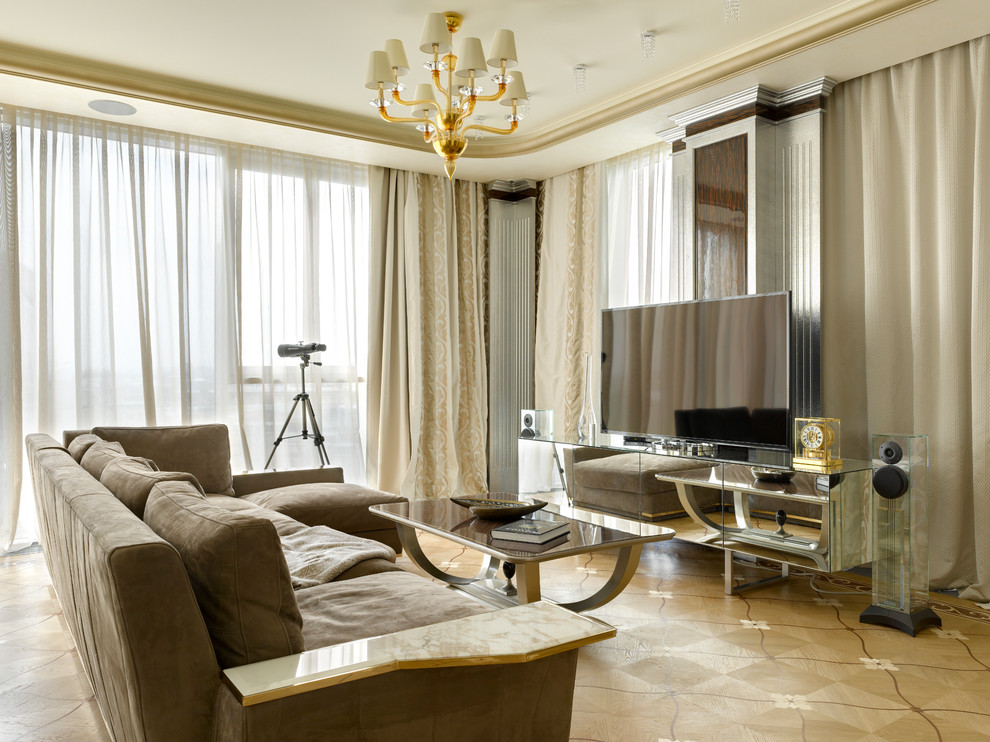 На фото: открытая гостиная комната в современном стиле с светлым паркетным полом, отдельно стоящим телевизором, бежевым полом и коричневым диваном с