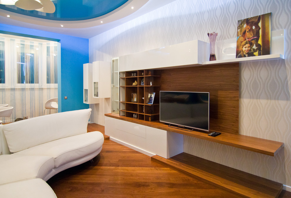 Стильный дизайн: открытая гостиная комната среднего размера в современном стиле с разноцветными стенами, паркетным полом среднего тона и отдельно стоящим телевизором - последний тренд