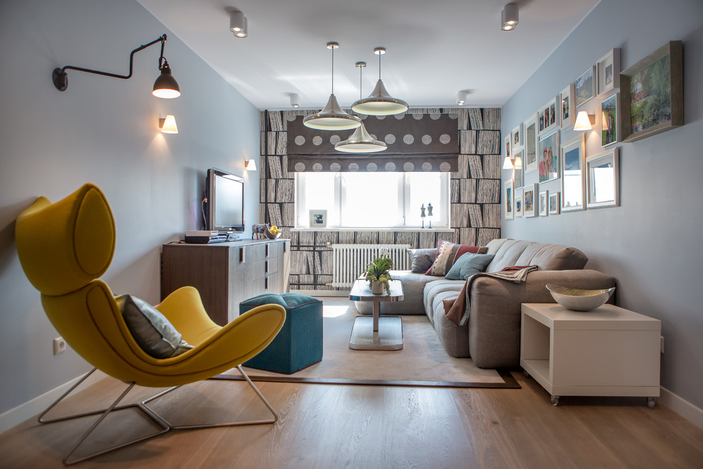 Foto på ett funkis vardagsrum, med ett finrum, grå väggar, ljust trägolv och en fristående TV