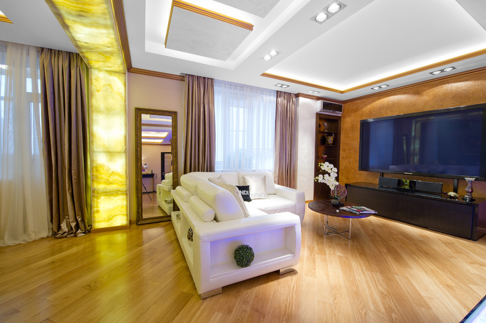 Пример оригинального дизайна: большая открытая гостиная комната в современном стиле с бежевыми стенами, светлым паркетным полом, телевизором на стене и музыкальной комнатой без камина