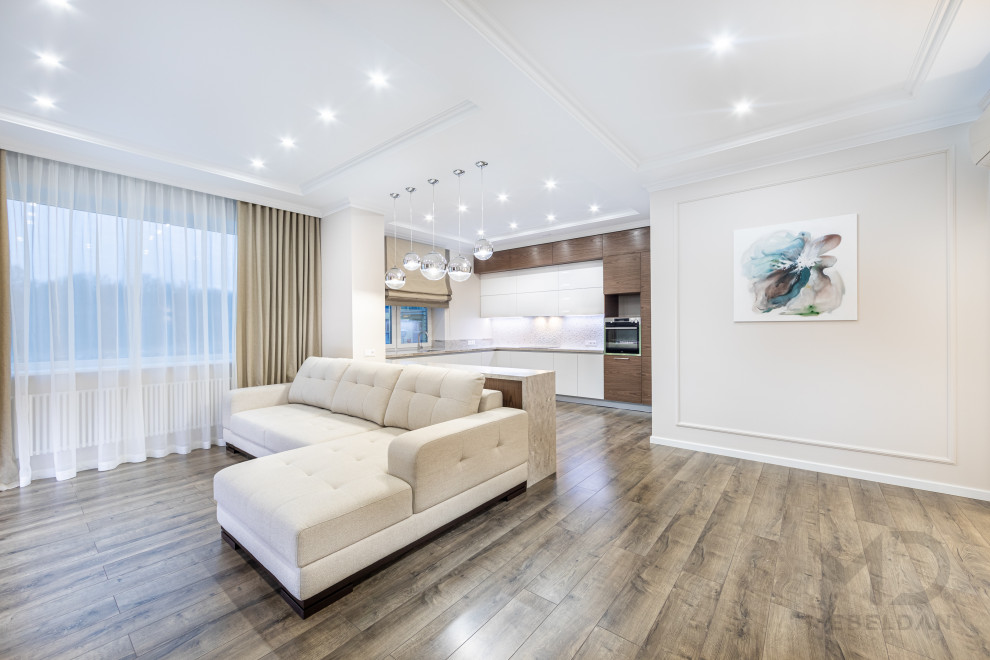 Modelo de salón contemporáneo grande con paredes blancas, suelo de madera en tonos medios y televisor colgado en la pared