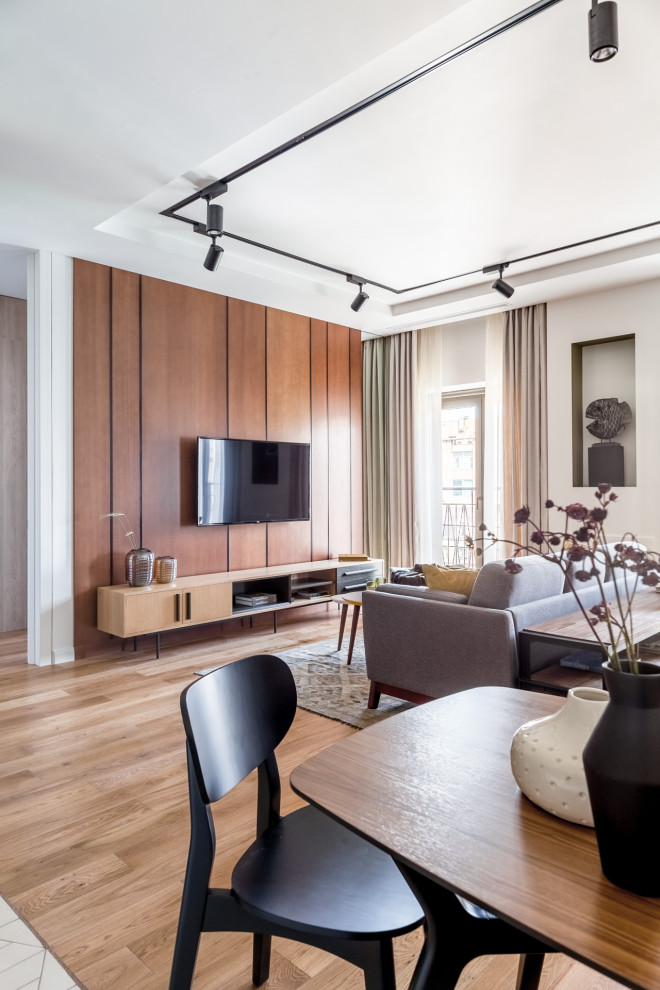 Идея дизайна: открытая, объединенная гостиная комната среднего размера в скандинавском стиле с белыми стенами, паркетным полом среднего тона, телевизором на стене и коричневым полом без камина