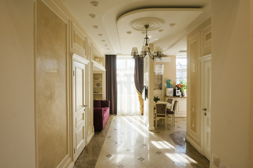 Imagen de salón abierto tradicional con paredes beige, suelo de baldosas de porcelana, televisor colgado en la pared y suelo beige