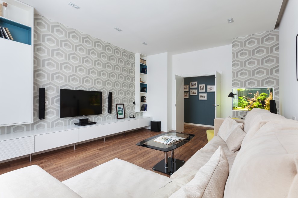 Стильный дизайн: изолированная, парадная гостиная комната среднего размера в современном стиле с белыми стенами, телевизором на стене и коричневым полом - последний тренд