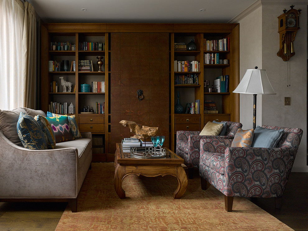 Aménagement d'une salle de séjour éclectique de taille moyenne et ouverte avec parquet foncé, un mur beige, un téléviseur dissimulé et une bibliothèque ou un coin lecture.