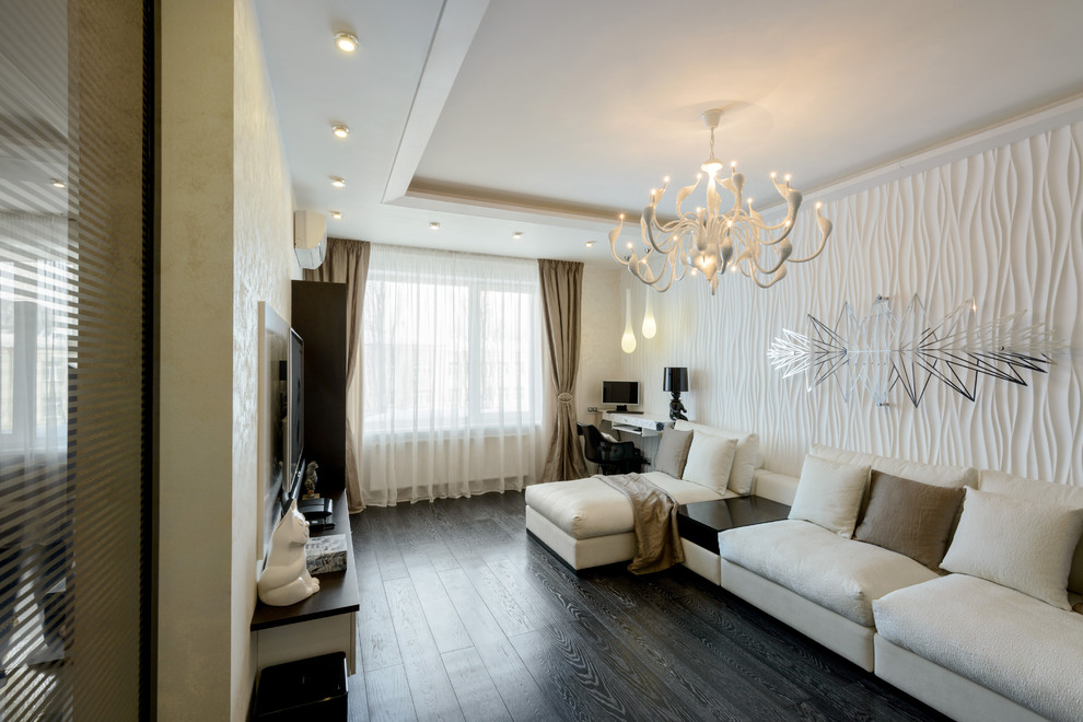 Свежая идея для дизайна: гостиная комната в современном стиле с белыми стенами, темным паркетным полом и телевизором на стене - отличное фото интерьера