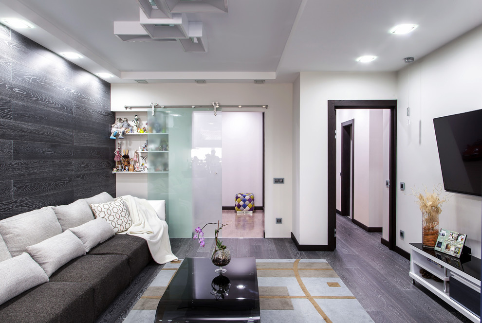 На фото: большая открытая, парадная гостиная комната в современном стиле с белыми стенами, деревянным полом и телевизором на стене с