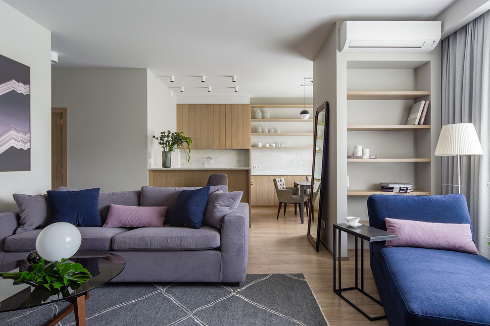 Diseño de salón para visitas abierto actual de tamaño medio con paredes grises y suelo de madera en tonos medios