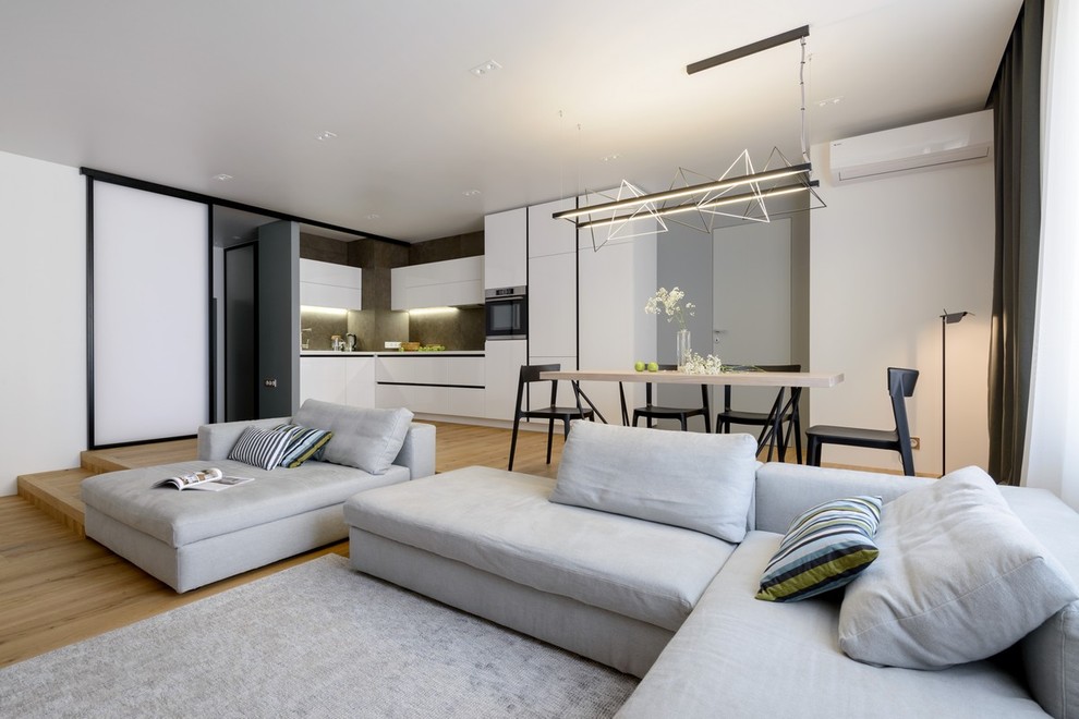 Immagine di un soggiorno contemporaneo aperto con sala formale, pareti bianche e pavimento in legno massello medio
