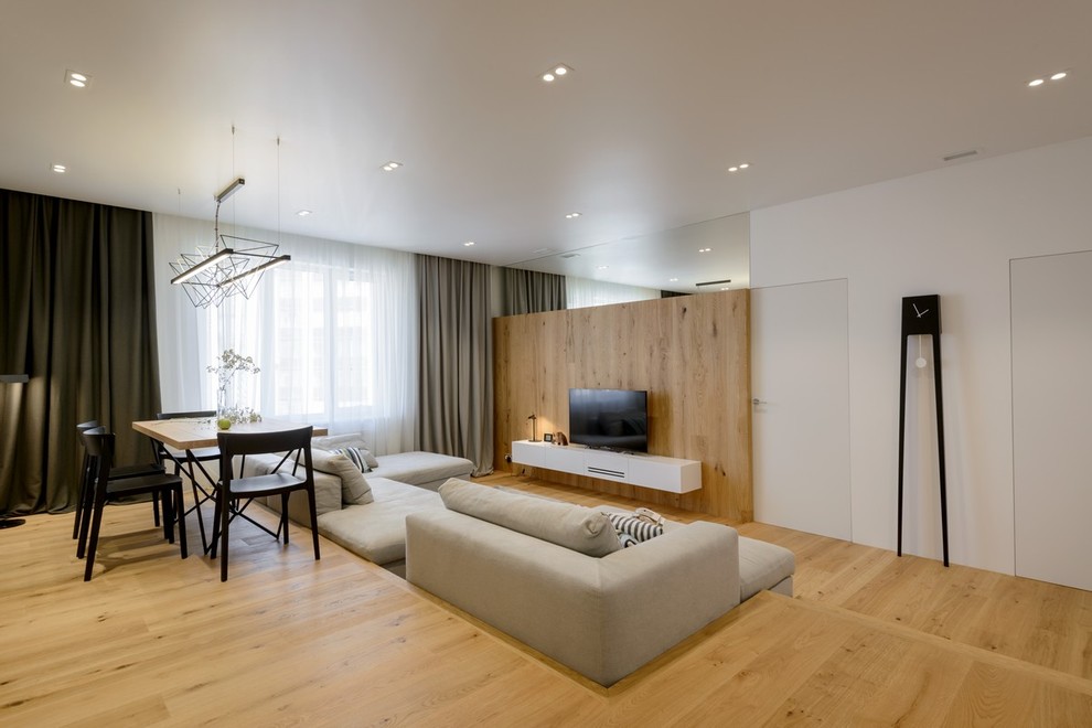Ejemplo de salón para visitas abierto contemporáneo con suelo de madera en tonos medios y televisor independiente