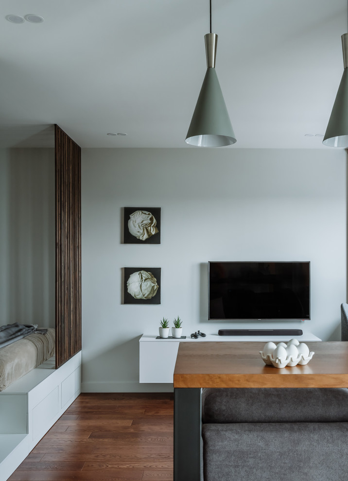 Пример оригинального дизайна: гостиная комната в современном стиле с телевизором на стене