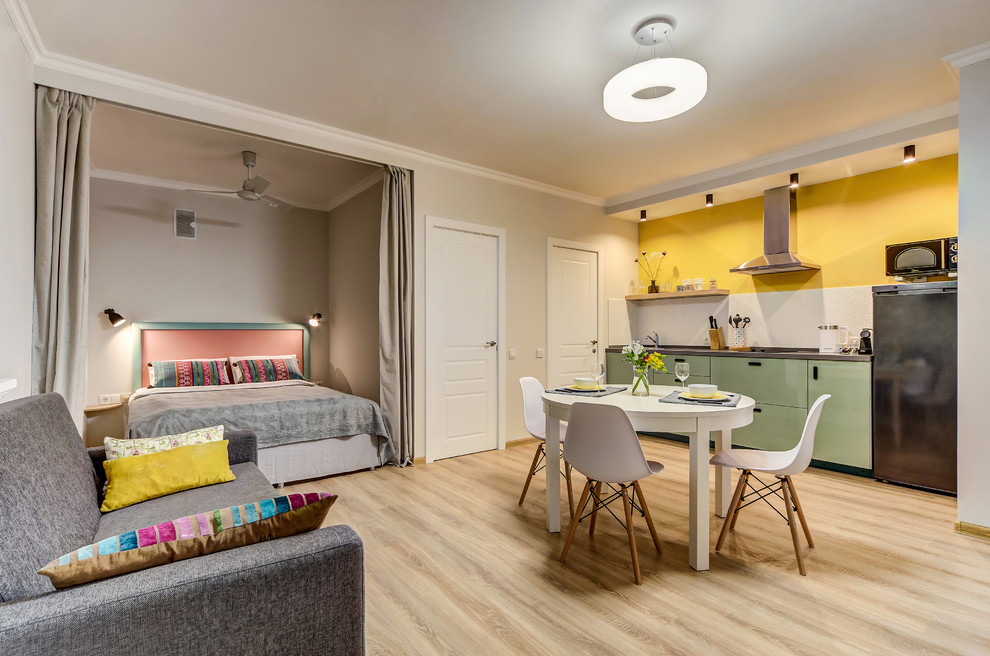 Свежая идея для дизайна: открытая, объединенная гостиная комната в современном стиле с бежевыми стенами, полом из ламината и коричневым полом - отличное фото интерьера