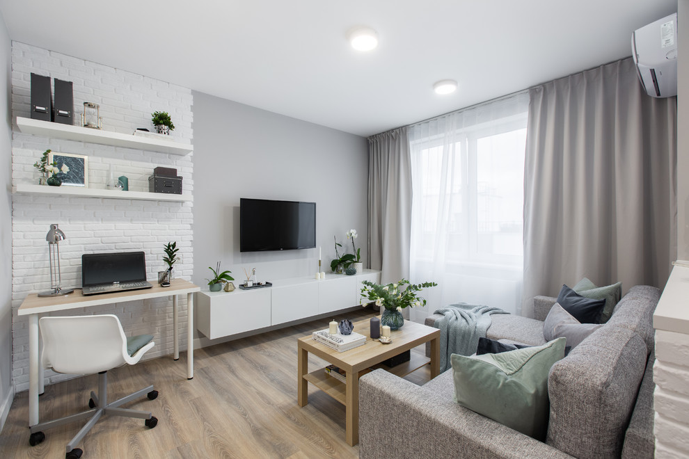 Immagine di un piccolo soggiorno contemporaneo aperto con pareti grigie, pavimento in laminato, TV a parete e pavimento beige