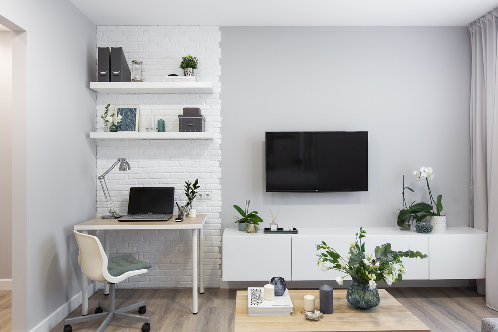 Diseño de salón abierto contemporáneo pequeño con paredes grises, suelo laminado, televisor colgado en la pared y suelo beige
