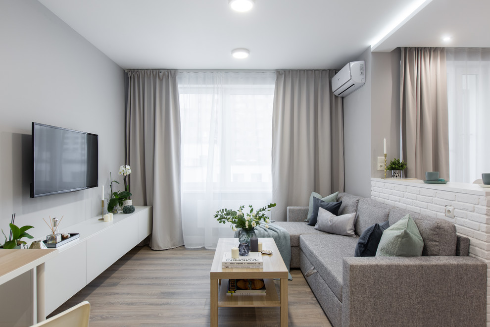 Immagine di un piccolo soggiorno design aperto con pareti grigie, pavimento in laminato, TV a parete e pavimento beige