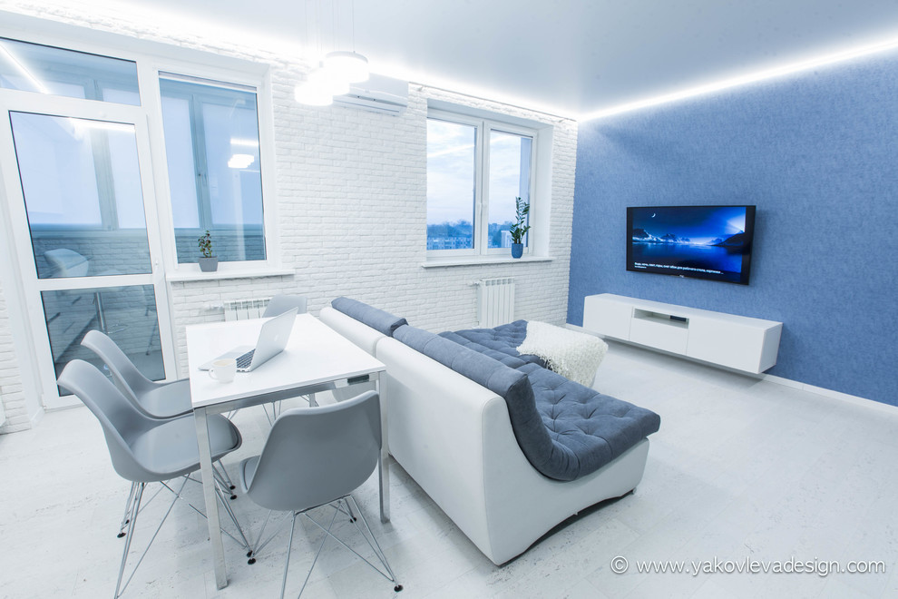 Exempel på ett mellanstort modernt allrum med öppen planlösning, med ett musikrum, blå väggar, korkgolv och en väggmonterad TV
