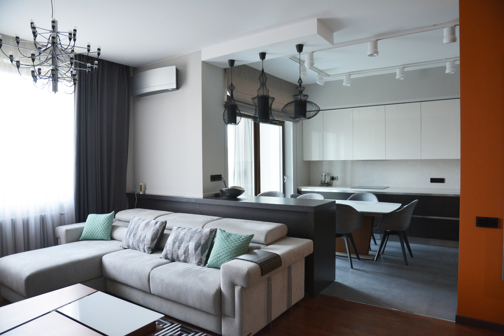 Источник вдохновения для домашнего уюта: открытая гостиная комната среднего размера в современном стиле с серыми стенами, паркетным полом среднего тона, телевизором на стене и коричневым полом