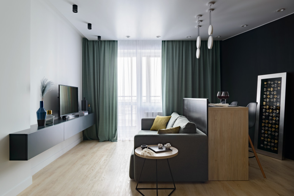 На фото: открытая, объединенная гостиная комната среднего размера в современном стиле с белыми стенами, полом из ламината, отдельно стоящим телевизором и бежевым полом
