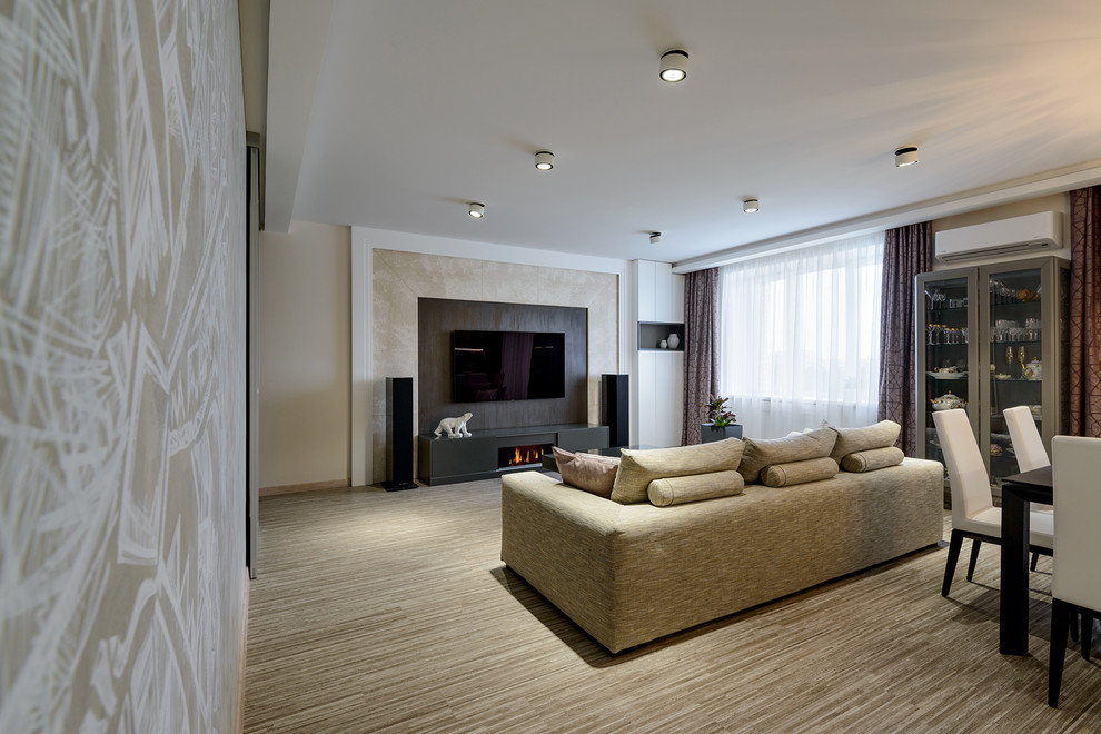 Modern inredning av ett mellanstort allrum med öppen planlösning, med beige väggar, korkgolv, en bred öppen spis, en väggmonterad TV och beiget golv