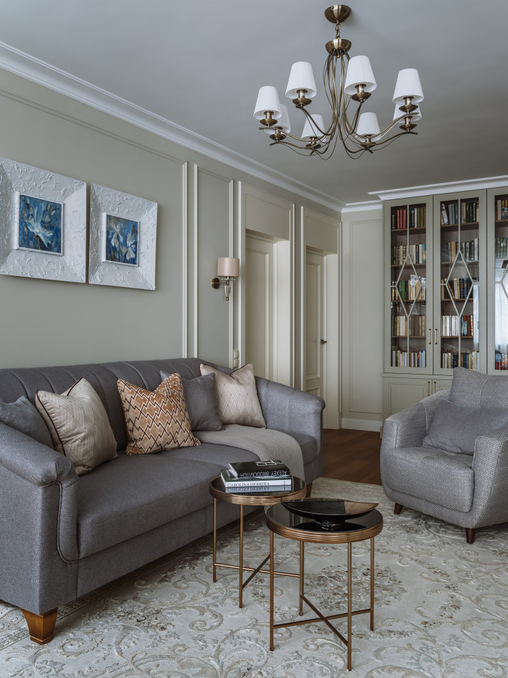 Foto di un soggiorno chic di medie dimensioni e aperto con libreria, pareti beige, pavimento in legno massello medio, TV a parete e pavimento beige